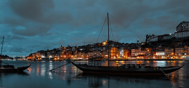 Linda e acolhedora cidade vintage do porto, em portugal, com barcos fluviais e cidade noturna amazing lights of the night city of porto