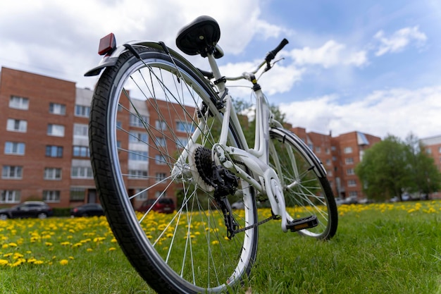 Linda e elegante bicicleta feminina branca em um fundo de grama verde