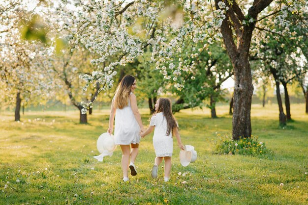 Linda e feliz mãe e filha em um jardim de primavera florescendo Amor parental no dia das mães