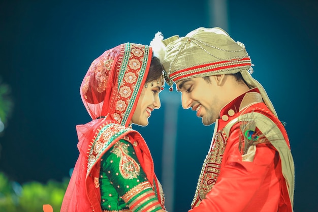 Linda e feliz noiva e noivo indianos vestindo sari Sherwani e joalheiro de casamento