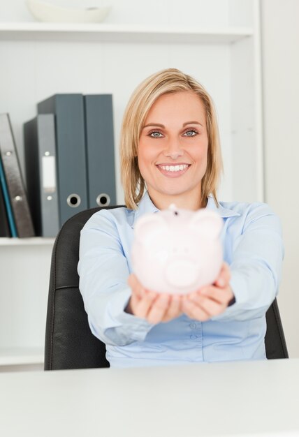 Linda empresária sorridente segurando um cofrinho