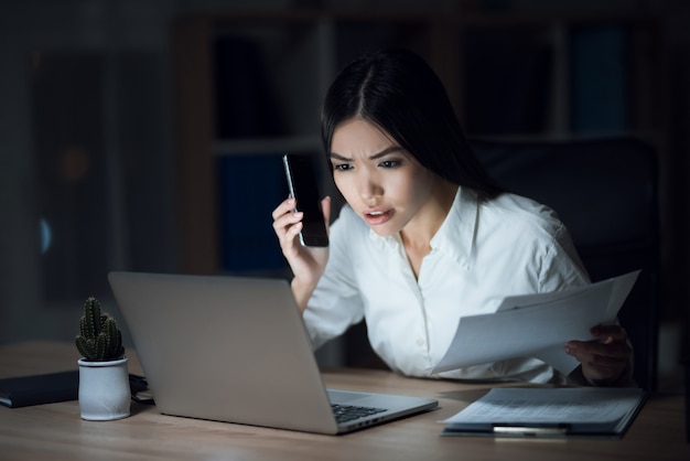 Linda empresaria trabajando en la oficina por la noche