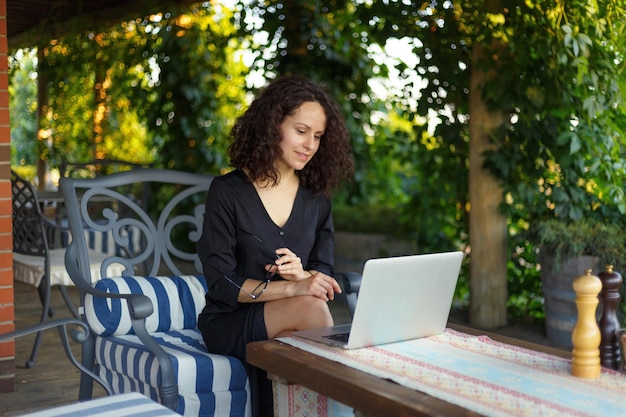 Linda empresária trabalhando em seu laptop posando no terraço