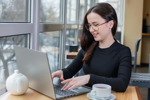 Linda empresária trabalhando em um laptop em uma freelancer feminina conectando