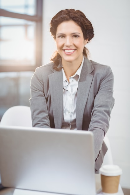 Linda empresária usando laptop no escritório