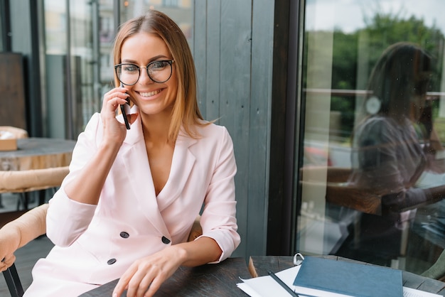 Linda empresária usando o telefone em um café