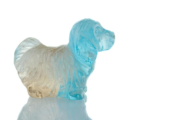 Linda estatueta de um cachorro do topázio mineral em um fundo branco