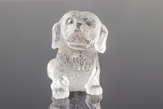 Linda estatueta de um cachorro do topázio mineral em um fundo cinza