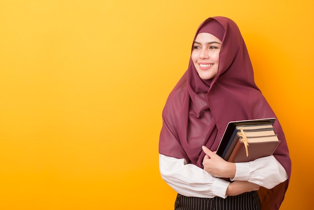 Linda estudante universitária com retrato de hijab em amarelo