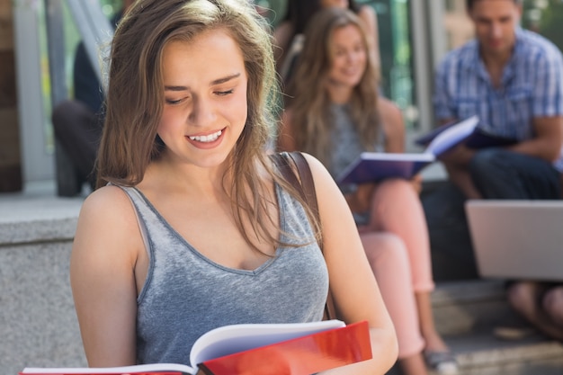 Linda estudiante leyendo desde el Bloc de notas