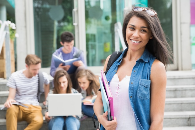 Linda estudiante sonriendo a la cámara fuera