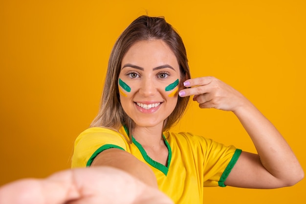 Linda fã brasileira caucasiana com rosto pintado tirando uma selfie