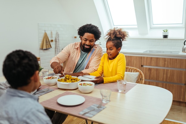 Linda família afro almoçando juntos em casa