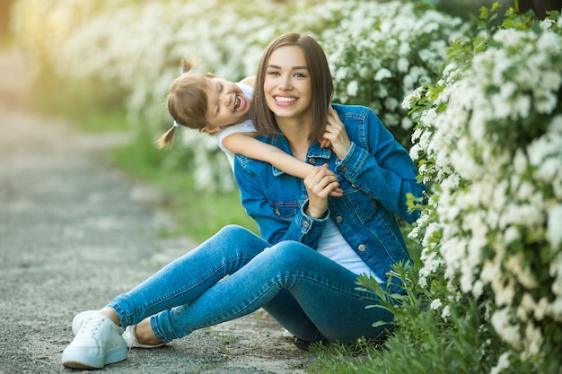 Linda familia al aire libre. Joven madre bonita con su pequeña hija