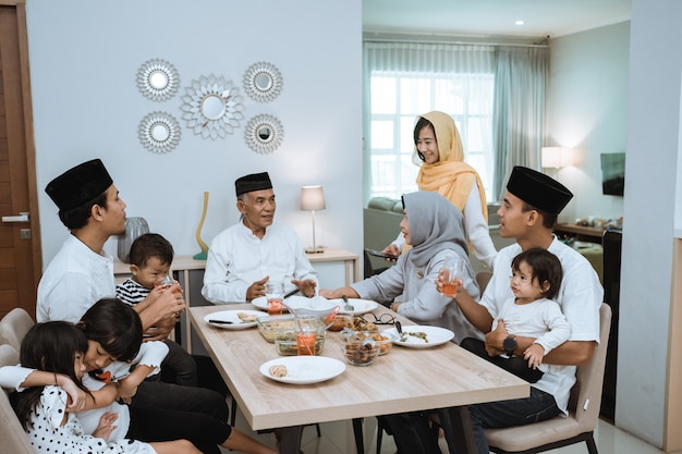 Linda família asiática desfrutando de seu jantar iftar em casa. Ramadan Kareem Islã quebra tradição de jejum