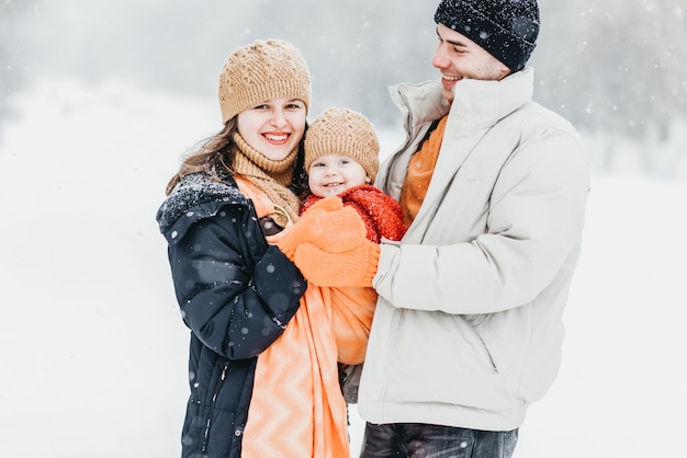 Linda família brincando no parque no inverno