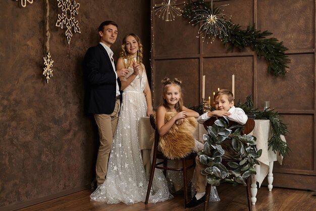 Linda família com dois filhos no quarto com decoração de natal