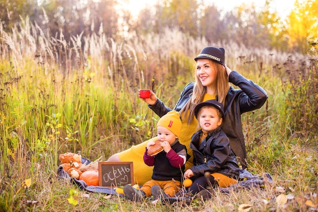 Linda família com um cachorro golden retriever em uma caminhada na natureza ensolarada de outono