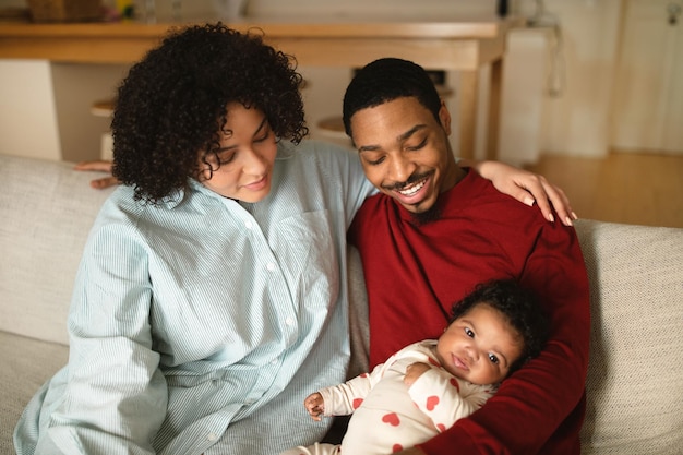 Linda família de raça mista posando com bebê em casa