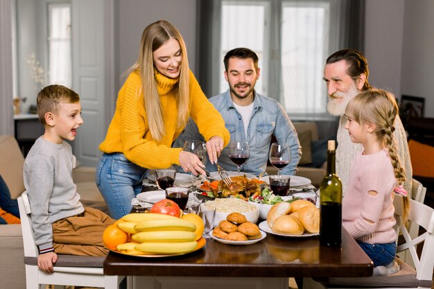 Linda família feliz, avô, pais e filhos, comemorando o dia de ação de graças juntos