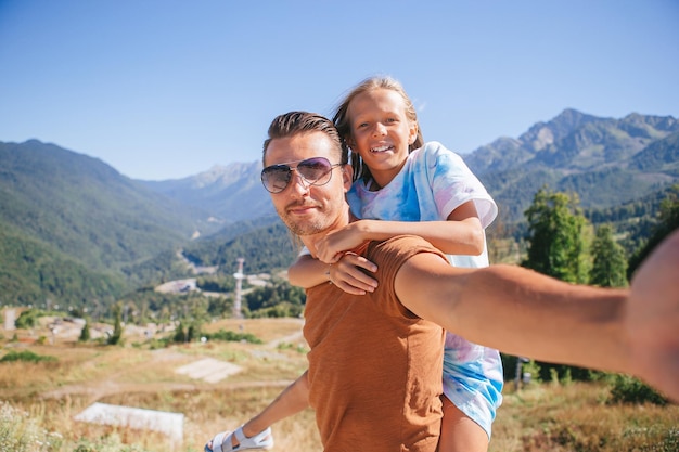 Linda família feliz nas montanhas ao fundo