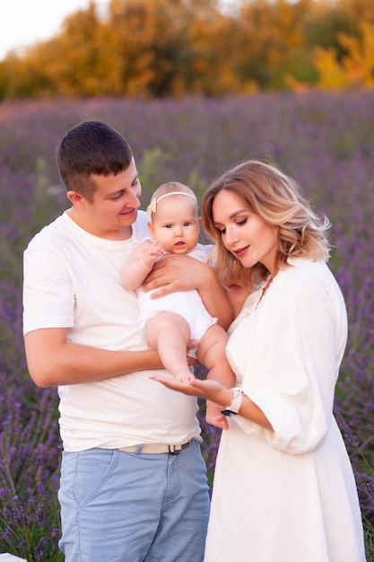 Linda família jovem no campo de lavanda flor roxa. férias em família