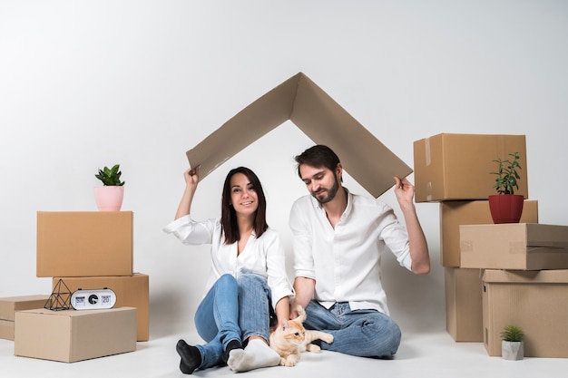 Linda familia joven posando junto a cajas de cartón