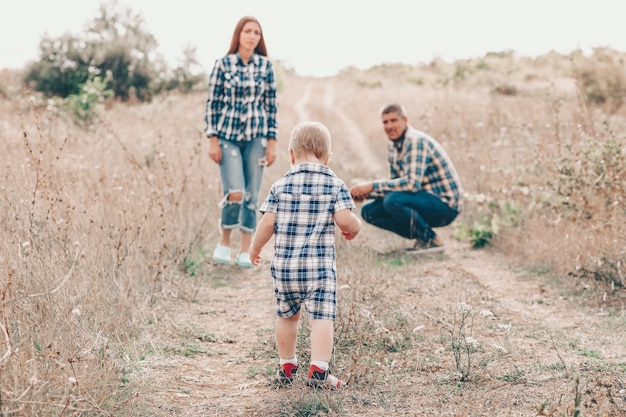 Linda familia jugando en un campo de otoño