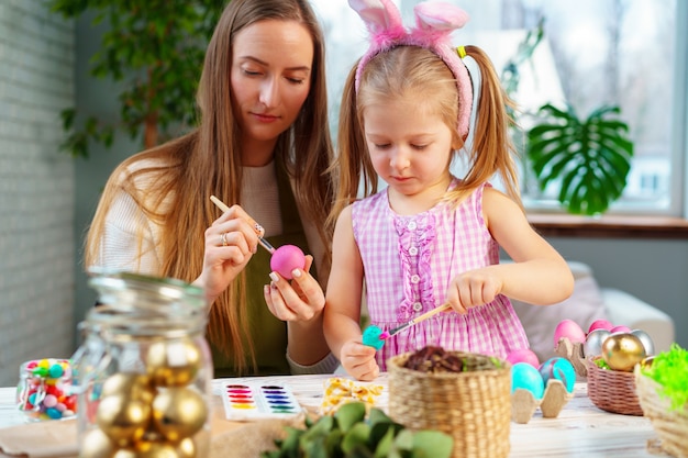 Linda familia, madre e hija preparándose para la celebración de Pascua