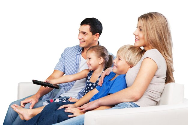 Linda família sorridente assistindo tv em casa