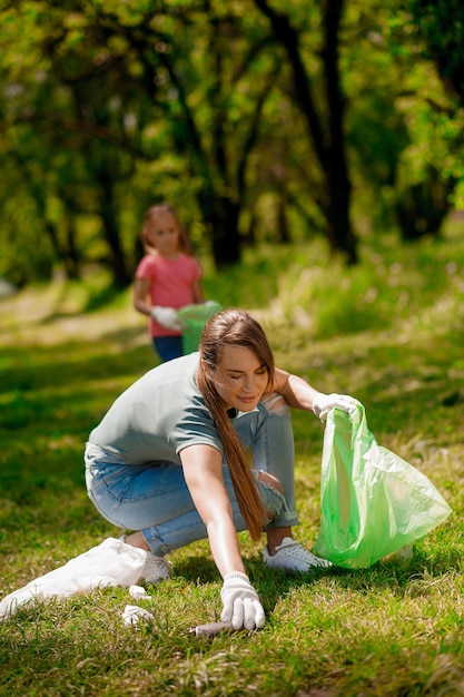 Linda familia trabajando en un parque recogiendo basura