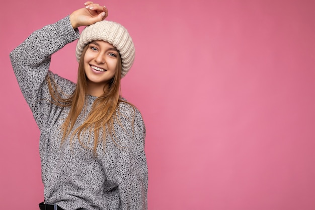 Linda feliz jovem loira escura, positiva, isolada sobre uma parede de fundo colorido, vestindo roupas casuais elegantes, sentindo emoções sinceras olhando para a câmera