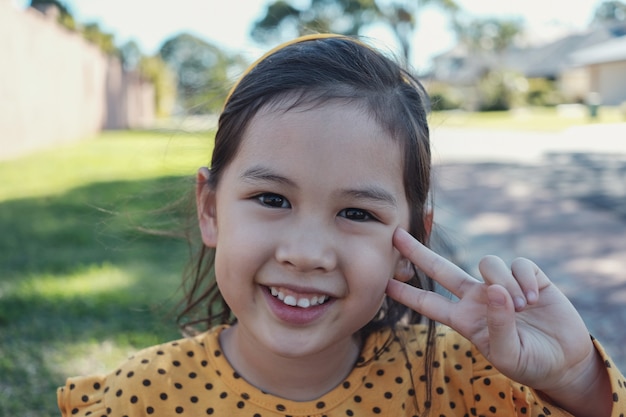 Linda feliz y saludable niña asiática mixta con lunares amarillos