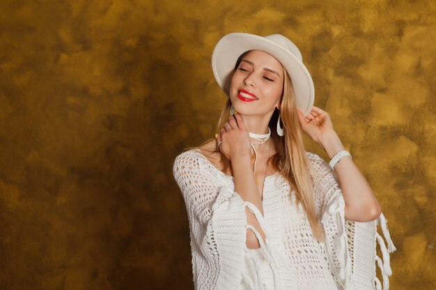 Linda felizmente vestida con estilo joven sonriente con cabello rubio con sombrero