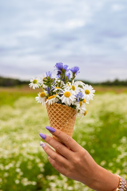 Linda flor em casquinha de sorvete na mão de garotas