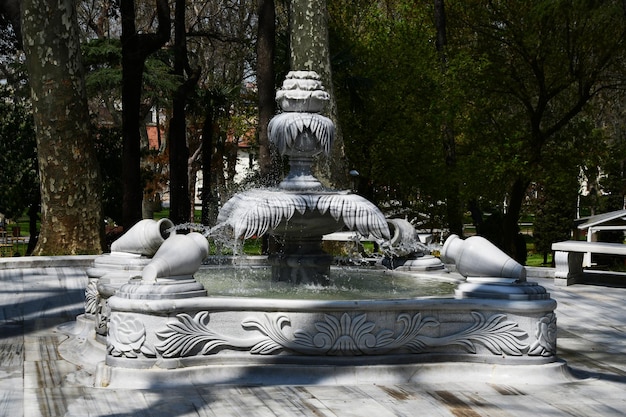 Linda fonte no parque Escultura em pedra De jarros despeje água na fonte