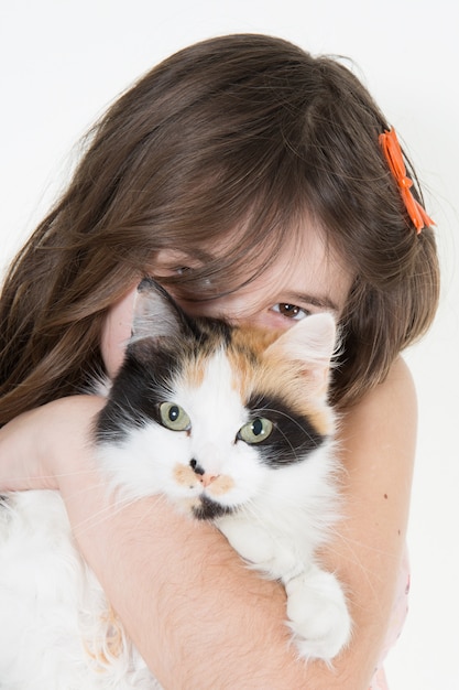 Linda garota abraçando um gatinho isolado no branco