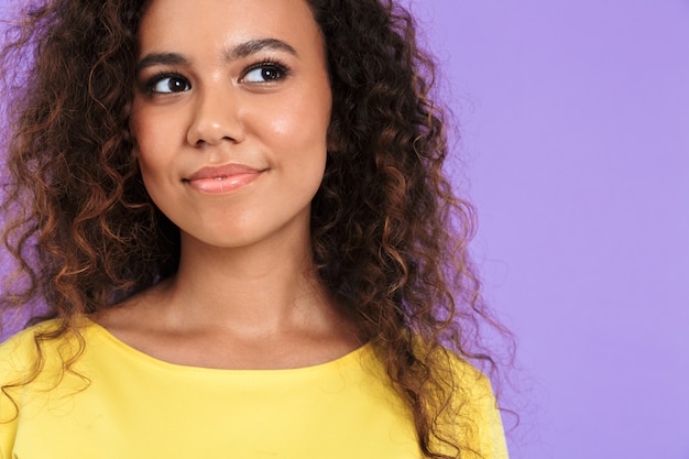 Foto linda garota africana usando roupas casuais, isolada na parede violeta