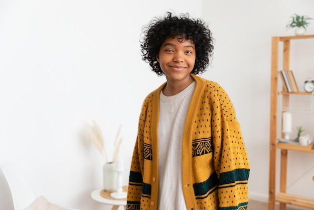 Linda garota afro-americana com penteado afro sorrindo em casa interior Jovem mulher africana com cabelos cacheados rindo na sala de estar Liberdade felicidade despreocupado conceito de pessoas felizes