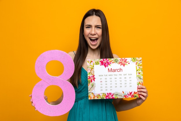 Linda garota alegre no dia da mulher feliz segurando o calendário com o número oito