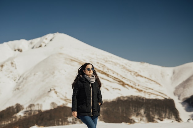 Linda garota, aproveitando o sol no dia de inverno nas montanhas dos Alpes.