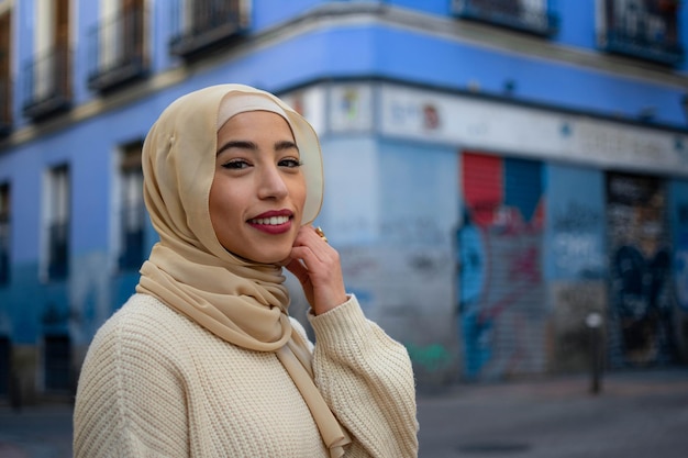 Linda garota árabe com hijab ao ar livre em fundo azul