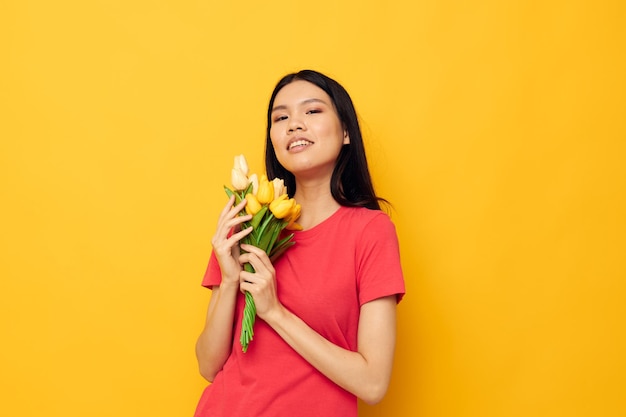 Linda garota asiática em camiseta vermelha com um buquê de flores