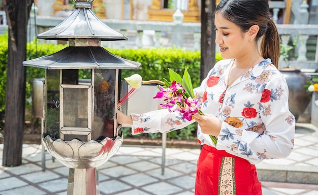 Linda garota asiática no grande templo budista vestida em traje tradicional