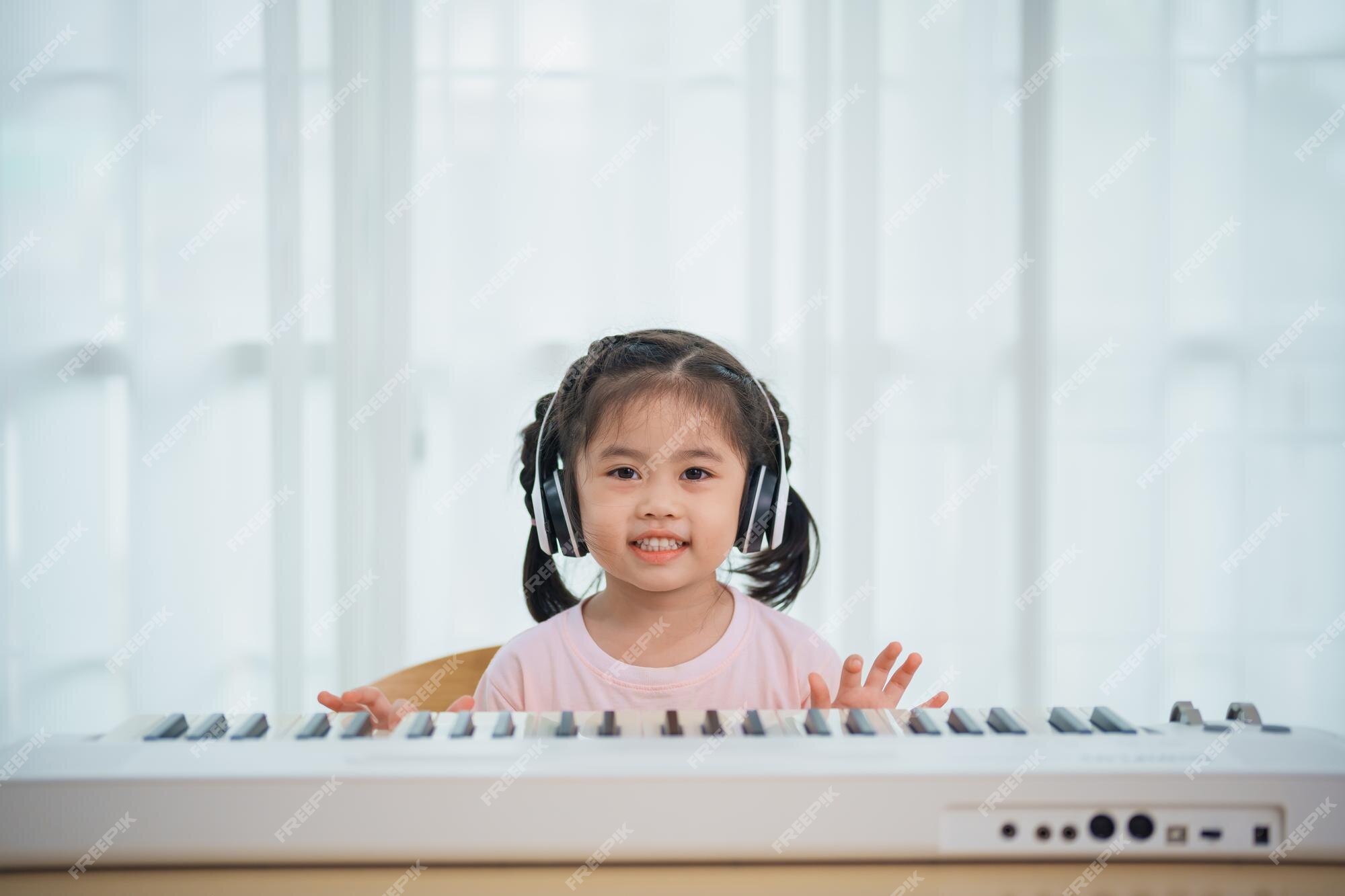 Linda garota asiática aprendendo música de piano online com