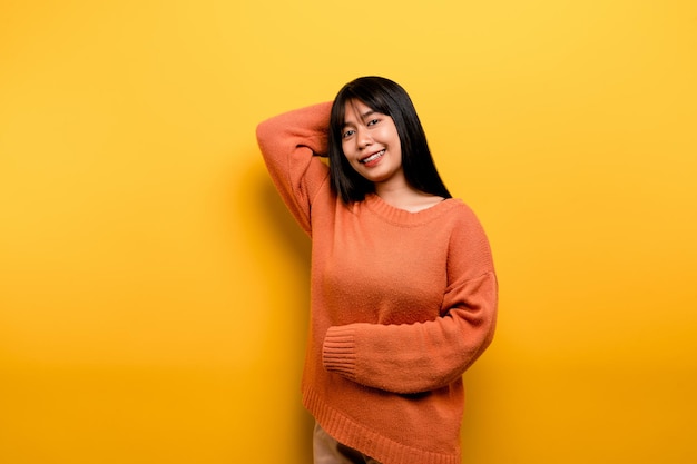 Linda garota asiática sorrindo em fundo amarelo Mulher jovem vazia Lugar para espaço de cópia de anúncio