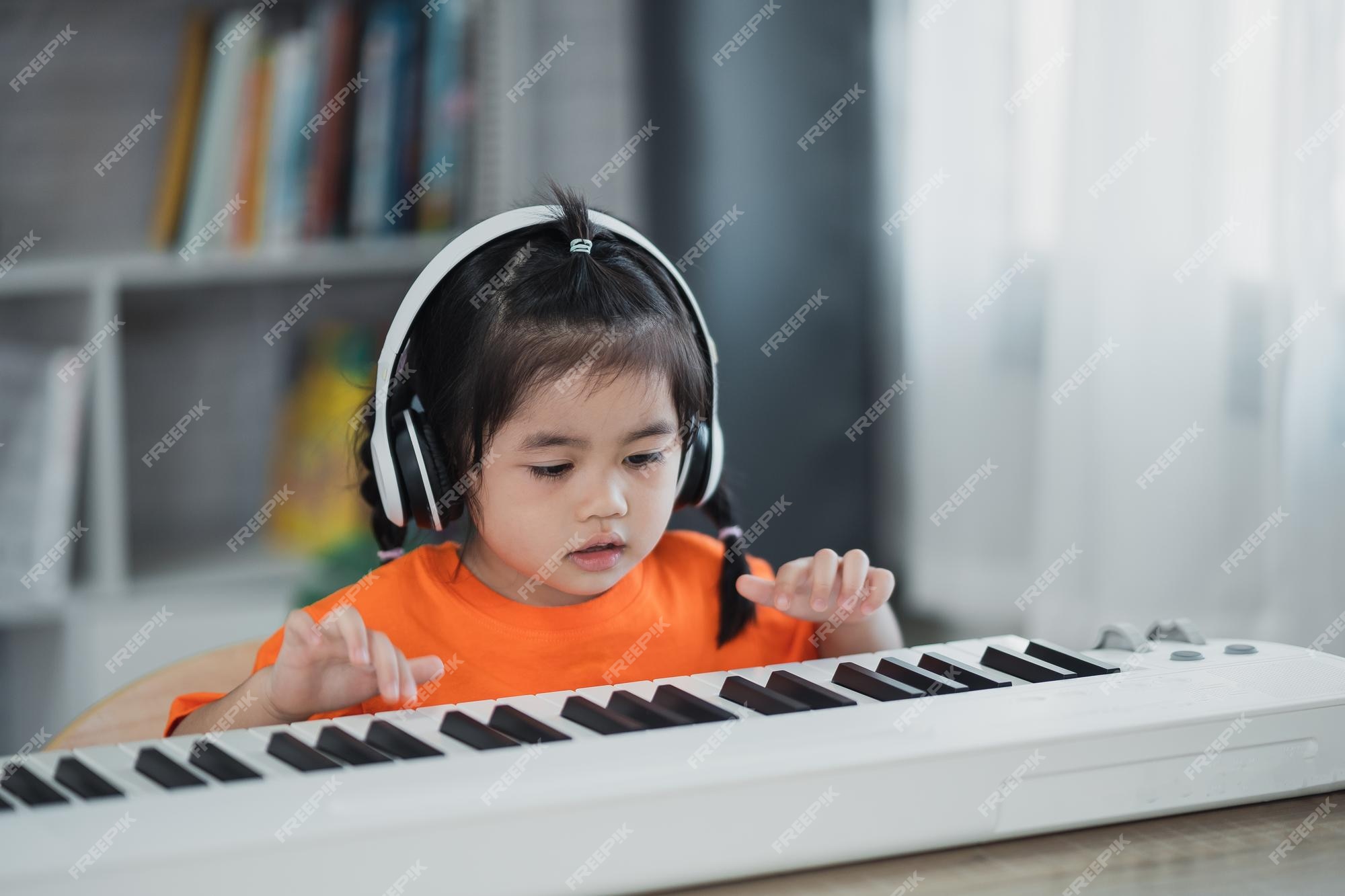 Linda garota asiática usando fone de ouvido aprendendo música de