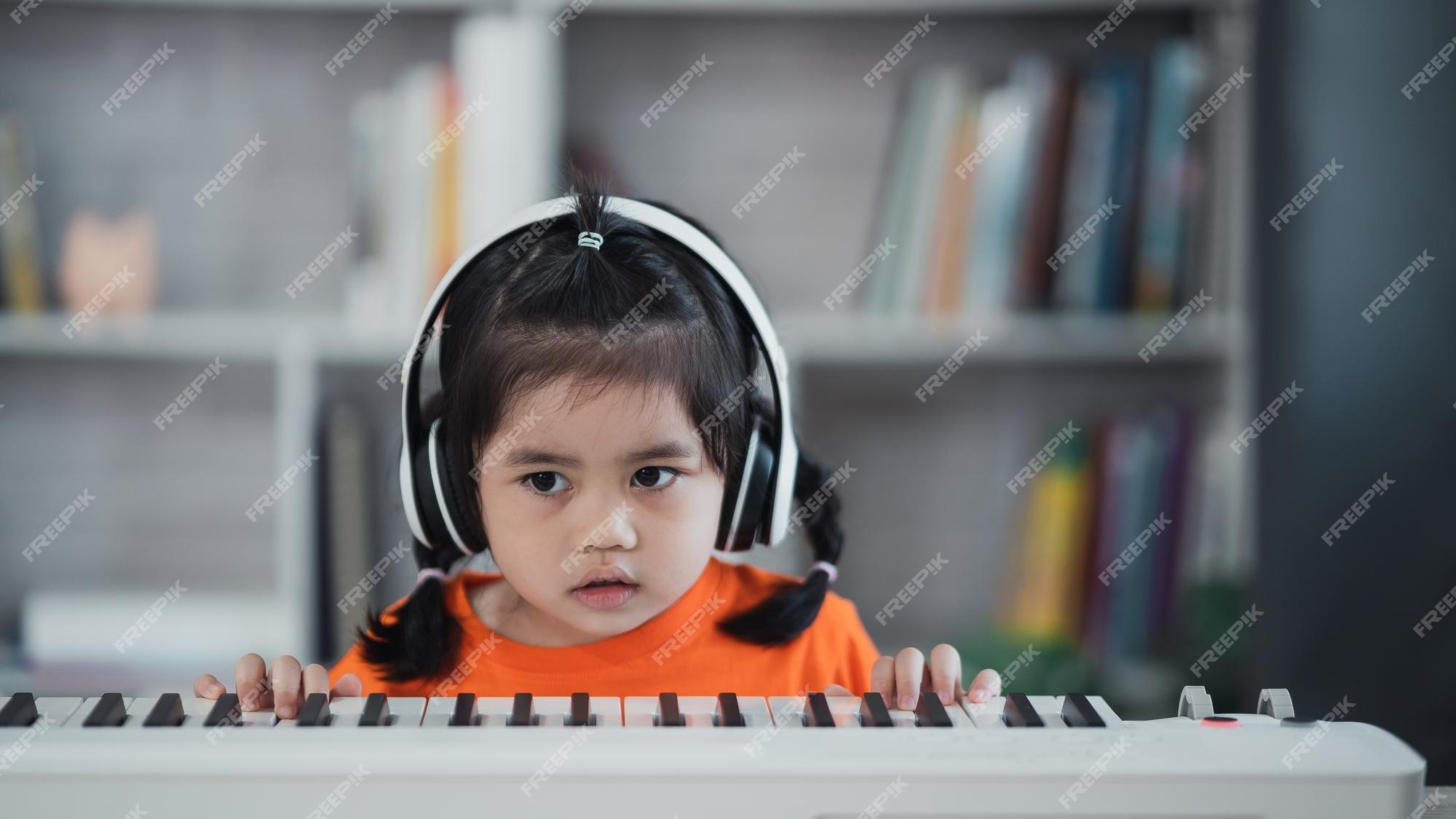 Linda garota asiática usando fone de ouvido aprendendo música de