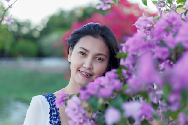 Foto linda garota atraente com flor colorida no parque