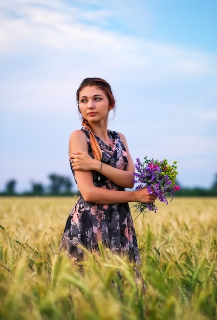 Linda garota atraente com um buquê de flores coloridas nas mãos dela.